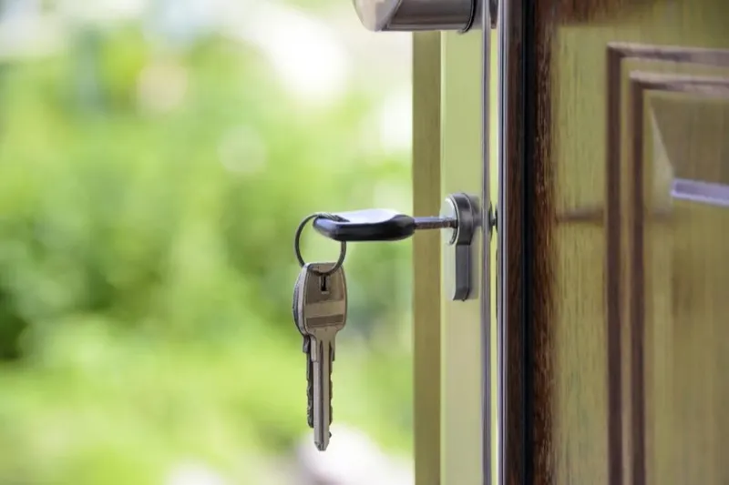House keys hanging from the lock of an open front door